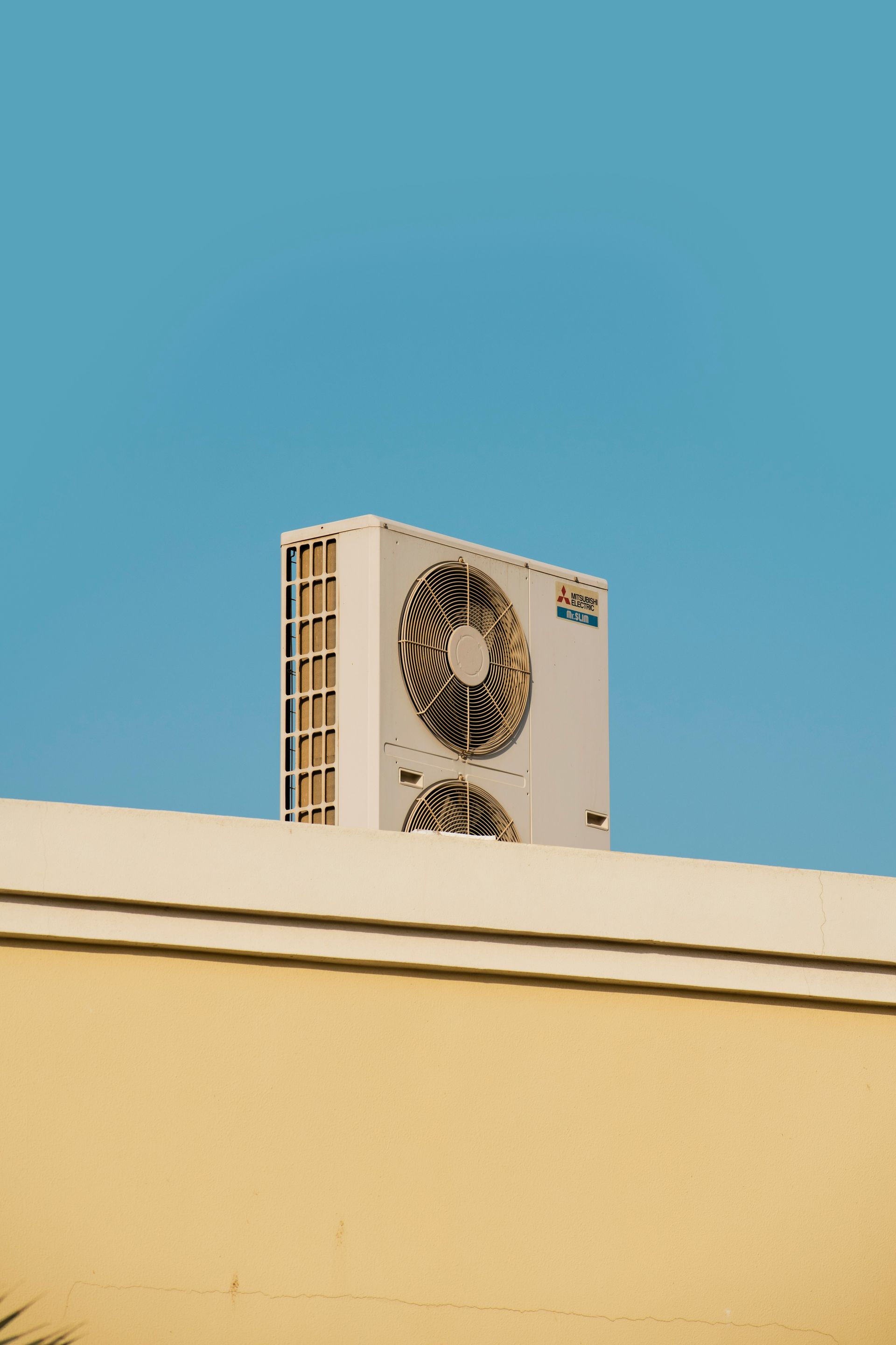 a white air conditioner sitting on top of a building